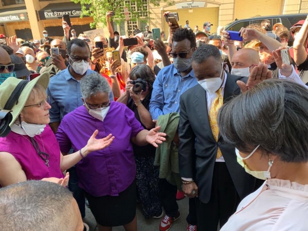 Bishop Budde and members of her staff pray with Protesters
